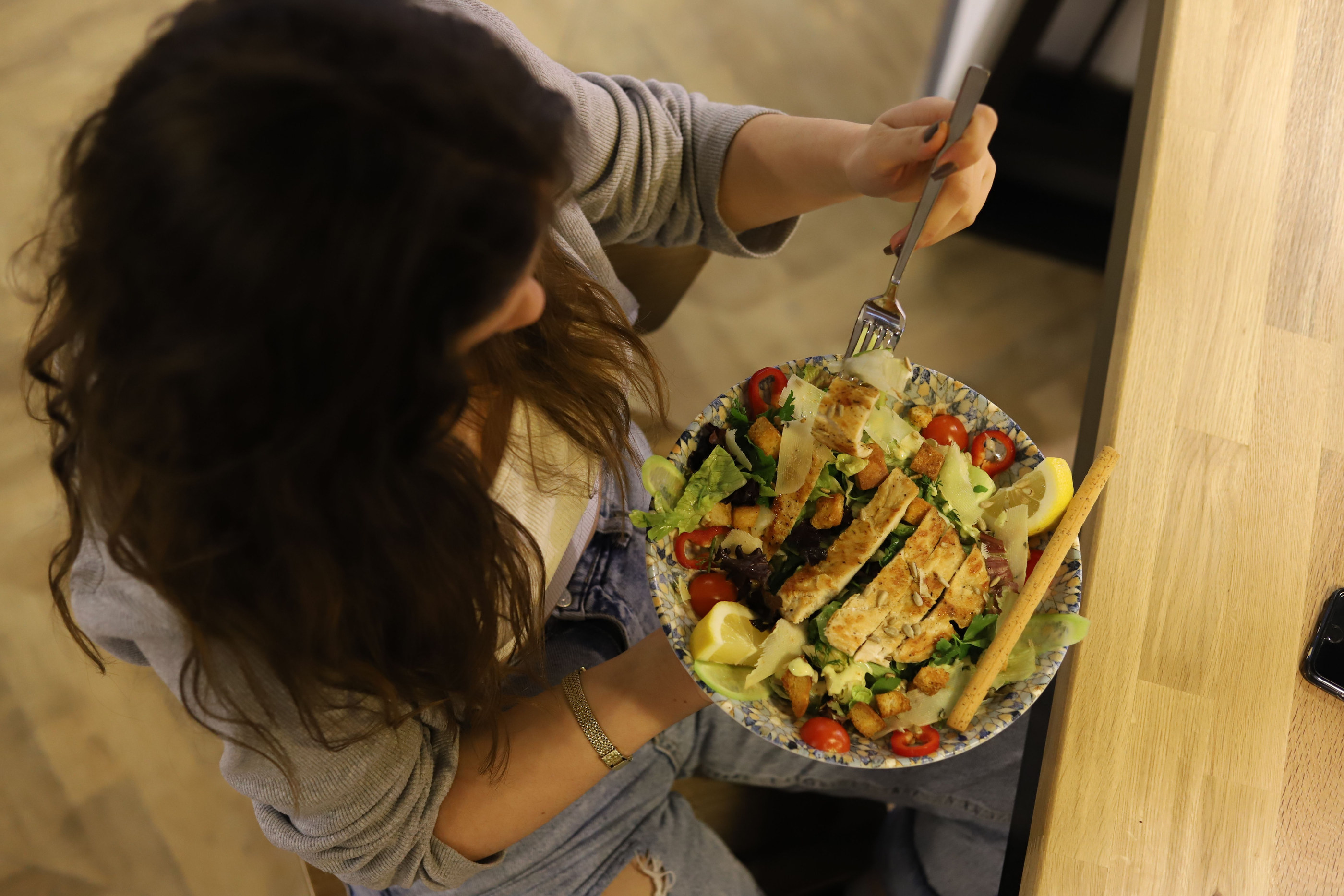 A fresh salad being served at a kitchen counter, seen from above.